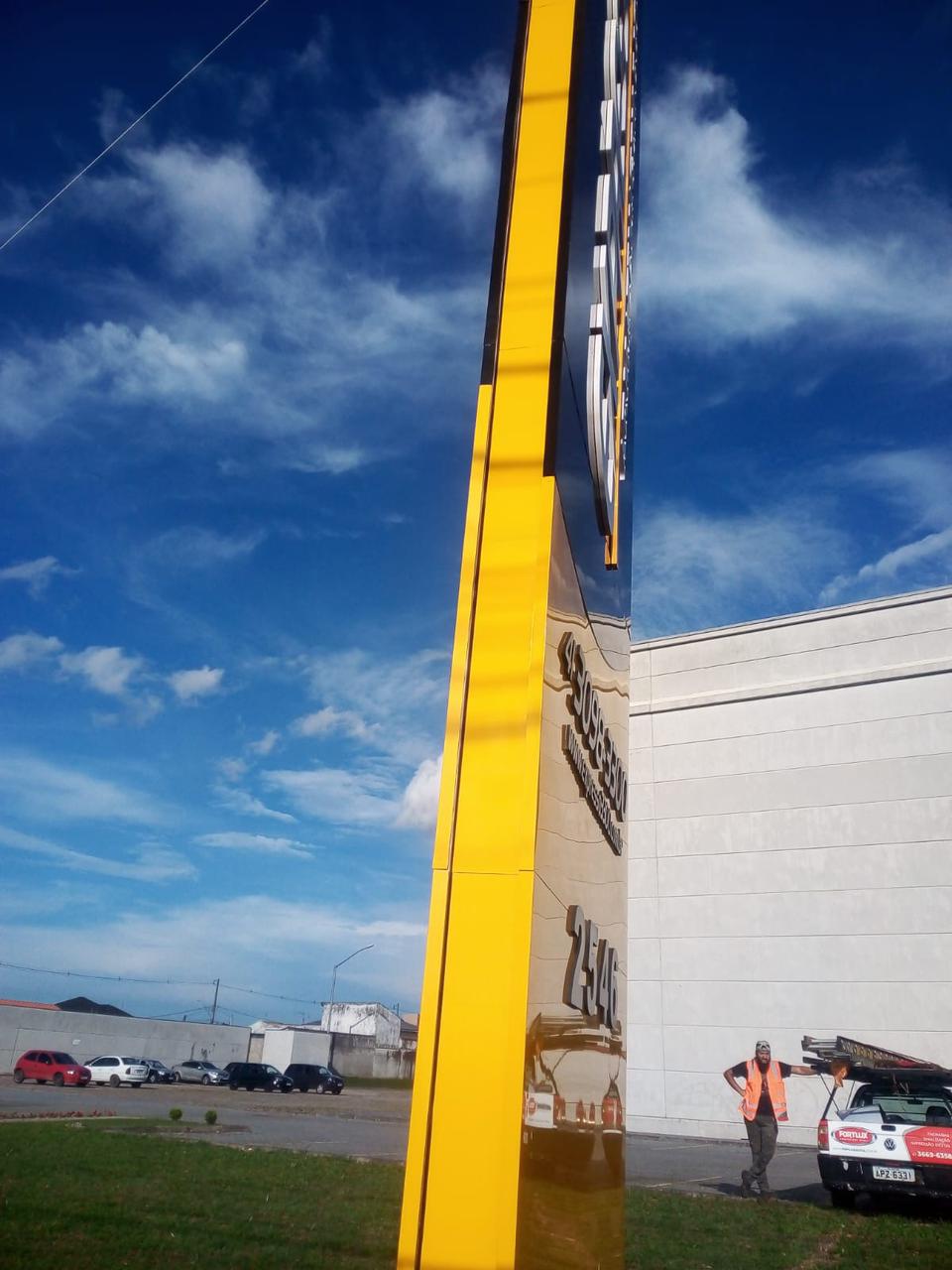 Detalhe da instalação de totem em ACM amarelo e preto